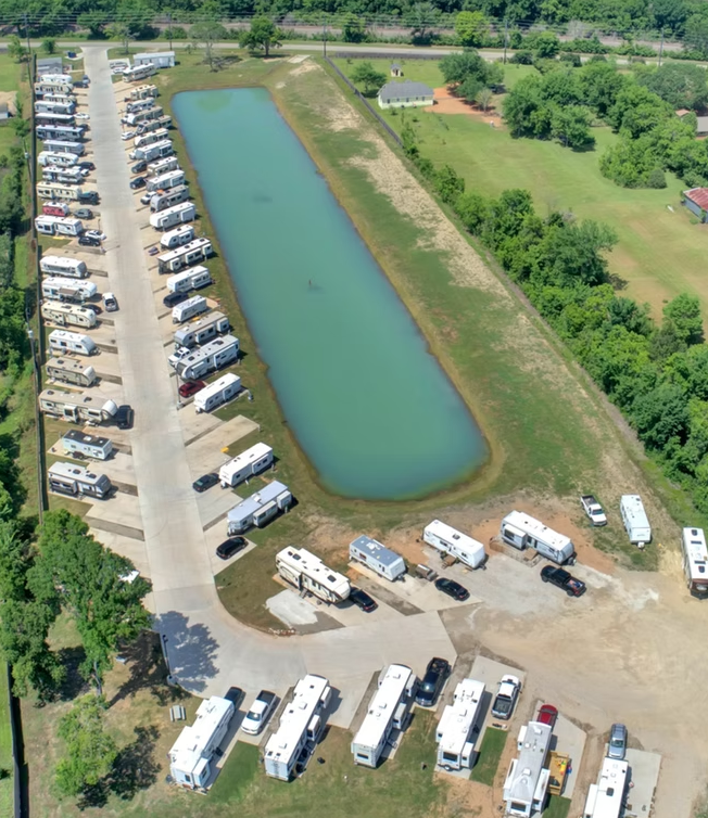 Aerial view of full RV park layout and pond