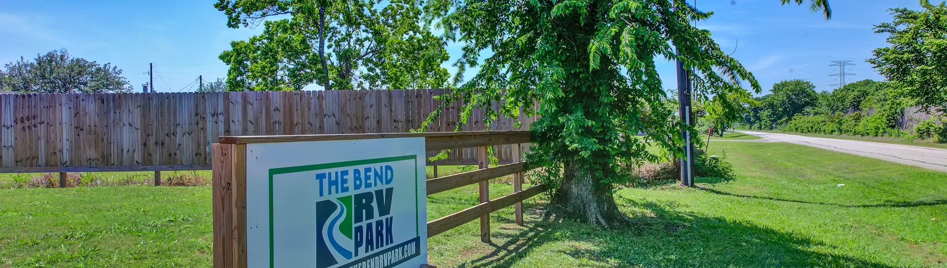 The Bend RV Park sign with fence and trees