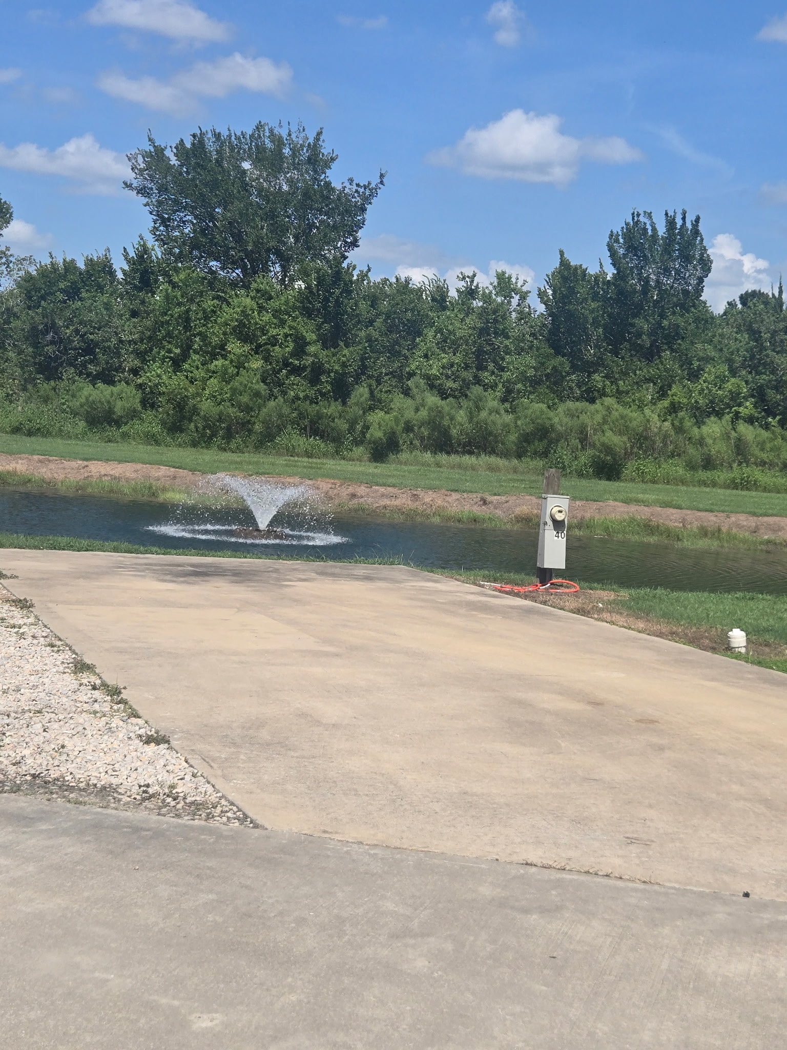 RV site next to the pond with fountain and hookup pedestal