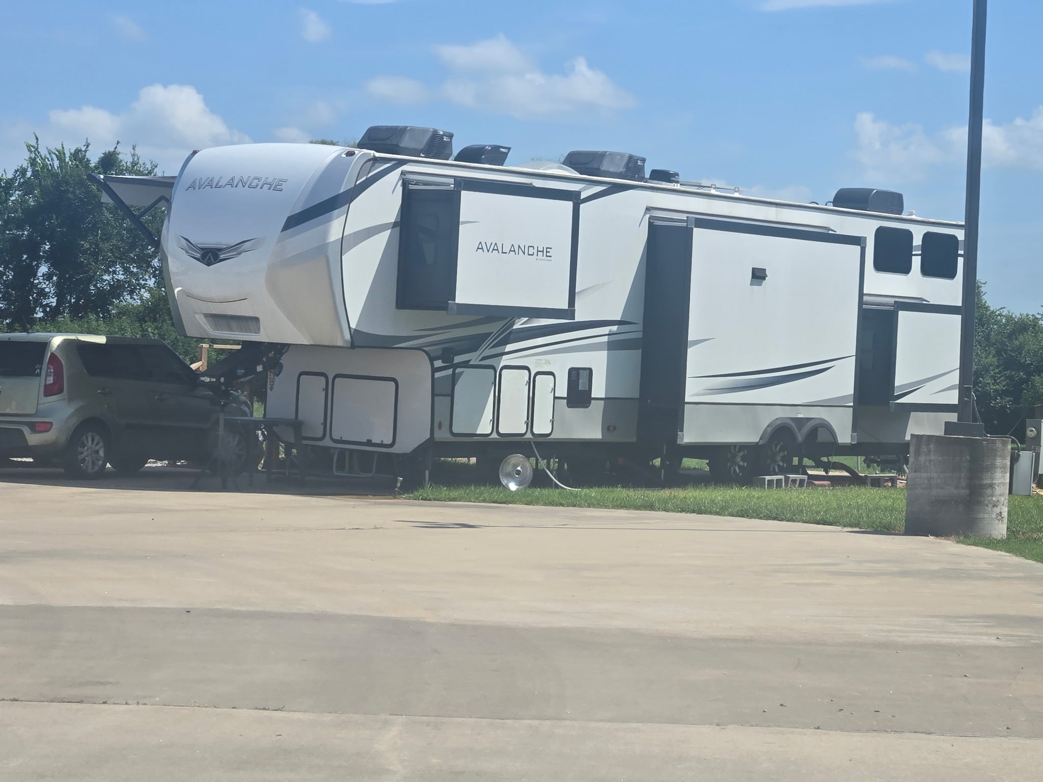 Large Avalanche fifth-wheel RV parked at a site